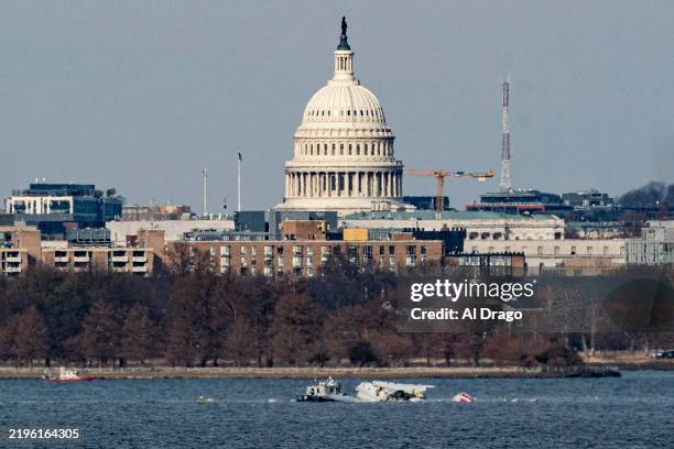 Emergency response units work at the crash site of the American Airlines plane on the Potomac River after the plane crashed last night on approach to...