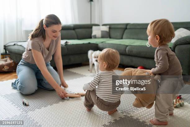 mother spending quality time with her little sons at home - eén dier stockfoto's en -beelden