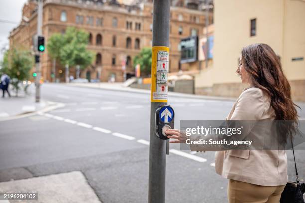 business professional waiting to cross a busy street in sydney's vibrant city center during the day - pedestrian stock pictures, royalty-free photos & images