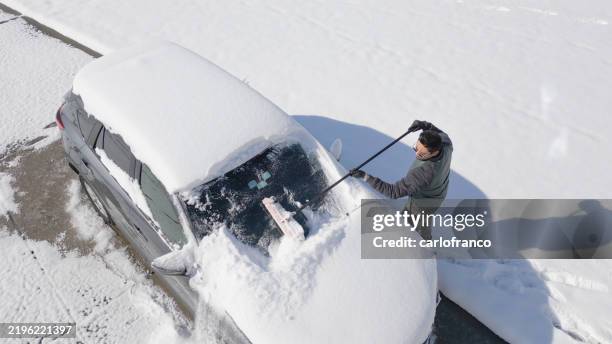 man removing snow from suv windshield- greenville north carolina - high angle - greenville nc stock pictures, royalty-free photos & images