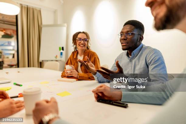 young businessman explaining his ideas during a meeting with colleagues - feedback stock pictures, royalty-free photos & images