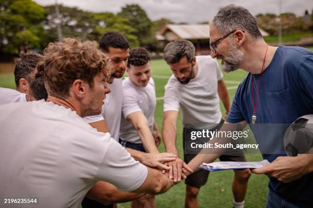teamwork and strategy session among young men on a soccer field in sydney, australia - leisure equipment stock pictures, royalty-free photos & images