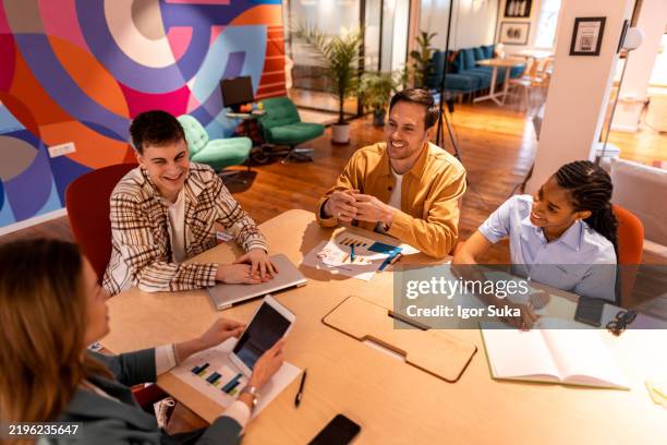 marketing-team diskutiert neues projekt während eines meetings im büro - quartett stock-fotos und bilder