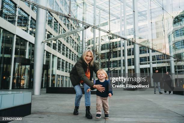 grandmother playing with grandson in front of modern building - centro sony de berlim imagens e fotografias de stock