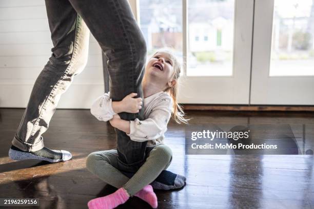 toddler girl holding on to fathers legs - parte inferior fotografías e imágenes de stock