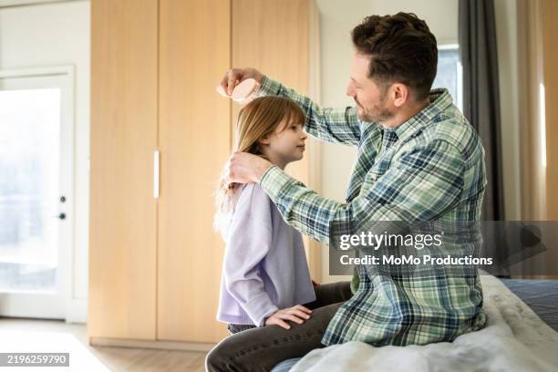 father brushing young daughters hair - house husband stock pictures, royalty-free photos & images