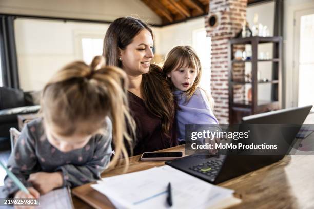 mother trying to work from home and care for two young daughters - famiglia con due figli foto e immagini stock