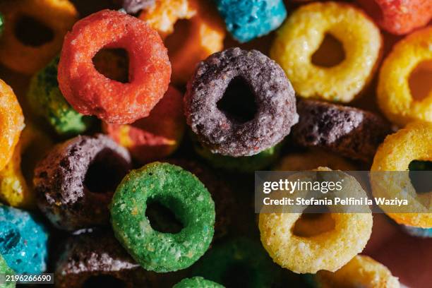 colorful, loop-shaped breakfast cereal rings are piled together, showcasing a mix of vibrant colors - food coloring stock pictures, royalty-free photos & images