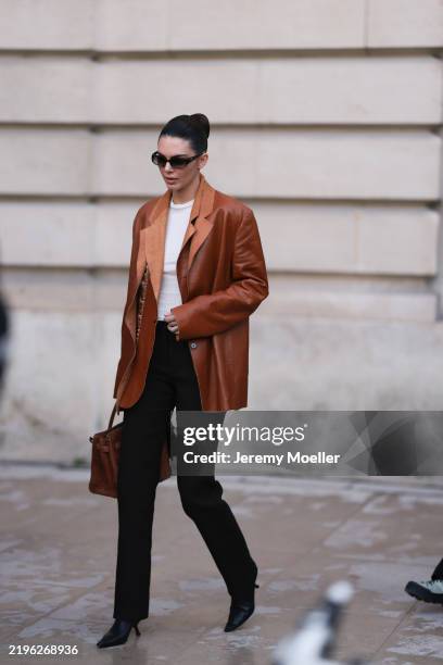 Kendall Jenner seen wearing a white shirt, brown leather blazer, black pants, black sunglasses, black heels, Hermes birkin suede brown 25 bag with...
