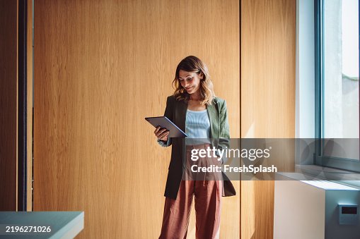 Joven profesional seguro de sí mismo que usa una tableta en un entorno de oficina moderno Joven profesional seguro de sí mismo que usa una tableta en un entorno de oficina moderno