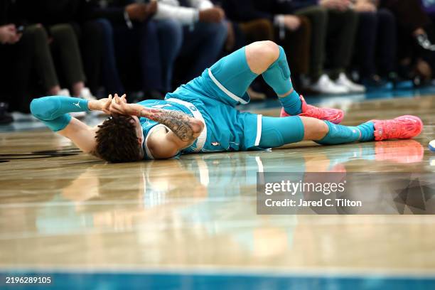 LaMelo Ball of the Charlotte Hornets falls to the ground following a left ankle sprain after colliding with Jarred Vanderbilt of the Los Angeles...