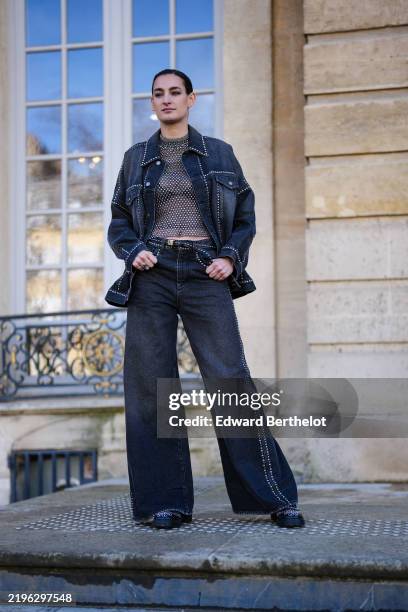 Nine d’Urso wears dark gray sheer mesh silver textured shirt, black bralette, navy blue silver embroidered denim jean jacket, navy blue silver...