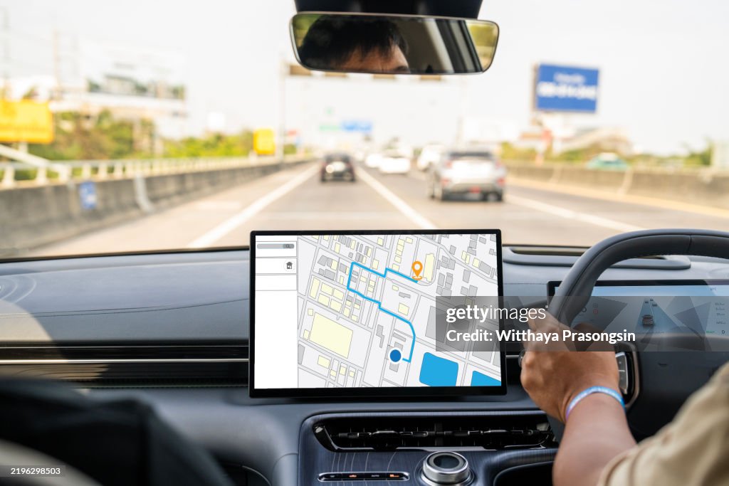 Driver Using Navigation System in a Modern Car on Highway