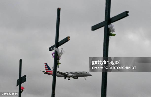 An American Airlines plane approaches to land past a makeshift memorial for the victims of the deadly mid air collision near Reagan National Airport...