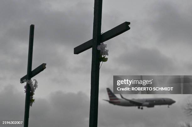 An American Airlines plane approaches to land past a makeshift memorial for the victims of the deadly mid air collision near Reagan National Airport...