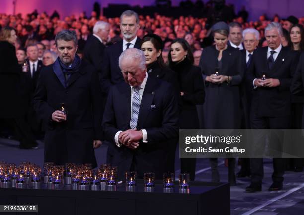 British King Charles III pauses after he placed a lit a candle in tribute to victims of the Holocaust as King Felipe VI of Spain, Queen Letizia of...