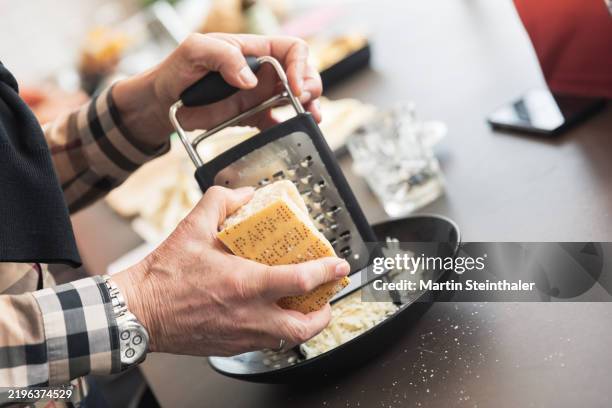 grating parmesan by hand - parmesan cheese stock pictures, royalty-free photos & images