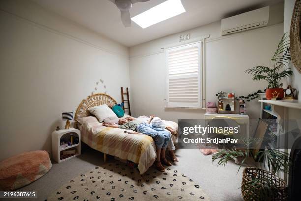 mother and daughter relaxing together on a colorful bed in a cozy bedroom - quarto arrumado imagens e fotografias de stock