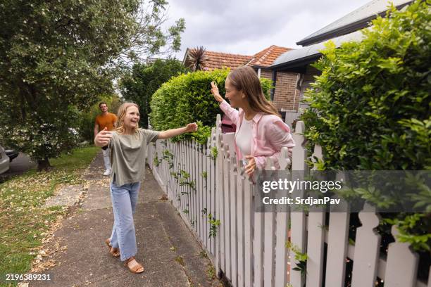 joyful family interaction outside a home on a sunny neighborhood street - hometown stock pictures, royalty-free photos & images