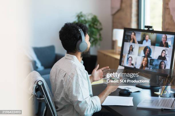 man in headphones participating in a virtual group meeting - telecommuting stock pictures, royalty-free photos & images