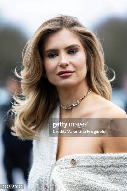 Xenia Adonts wears a Chanel gold choker and a Chanel tweed light beige coord-set outside Chanel show during Haute Couture Spring-Summer 2025 as part...