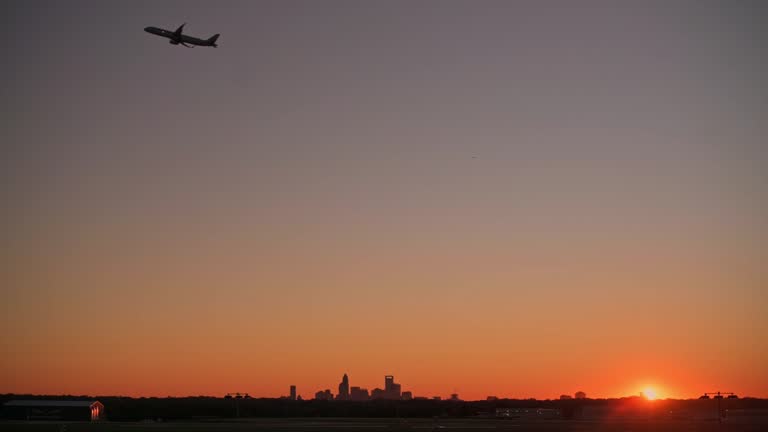https://media.gettyimages.com/id/2196436392/video/airplane-departing-at-sunrise-over-charlotte-skyline-silhouette-of-passenger-airplane-taking.jpg?b=1&s=640x640&k=20&c=cf7DBnY7NAMNZxP-ezDmp3nOu1eMtbD6W64y_MgPEz4=