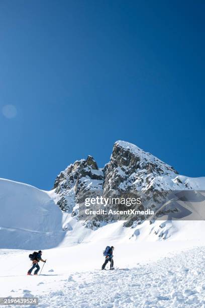 backcountry skiers climb mountain - off piste stock pictures, royalty-free photos & images
