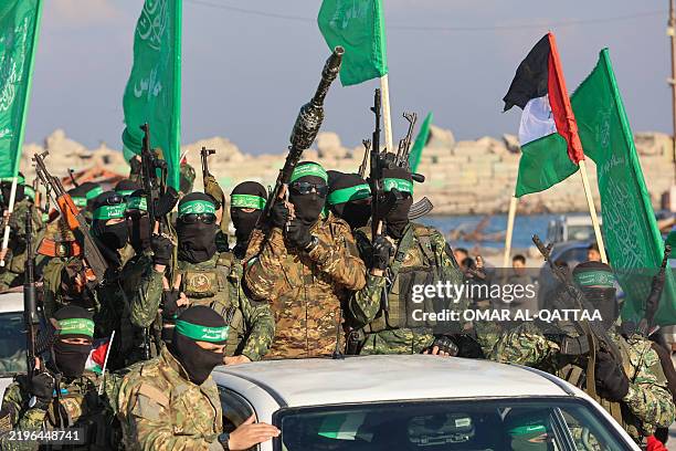 Palestinian militant group Hamas fighters secure an area before handing over an Israeli-America hostage to a Red Cross team in Gaza City on February...