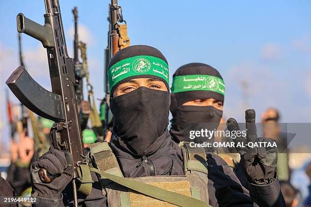 Palestinian militant group Hamas fighters secure an area before handing over an Israeli-American hostage to a Red Cross team in Gaza City on February...