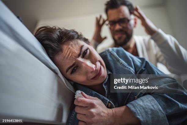 couple in conflict, woman is crying and a man appears visibly distressed - huiselijk geweld stockfoto's en -beelden