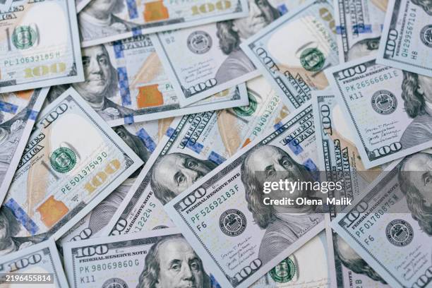 scattered hundred dollar bills depicting united states currency and wealth - unidade monetária dos estados unidos imagens e fotografias de stock