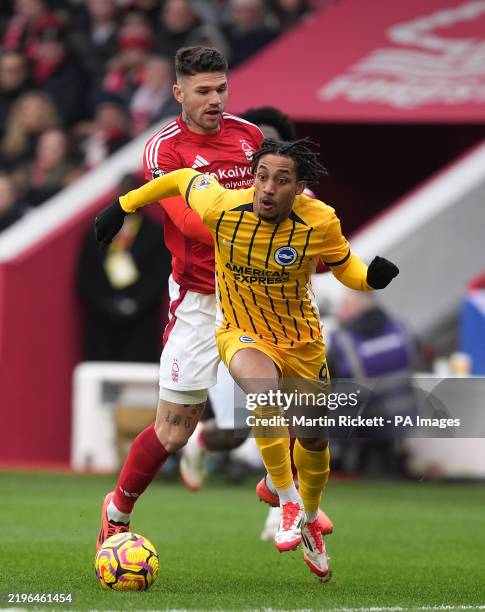 Brighton and Hove Albion's Joao Pedro runs with the ball followed by Nottingham Forest's Morato during the Premier League match at the City Ground,...