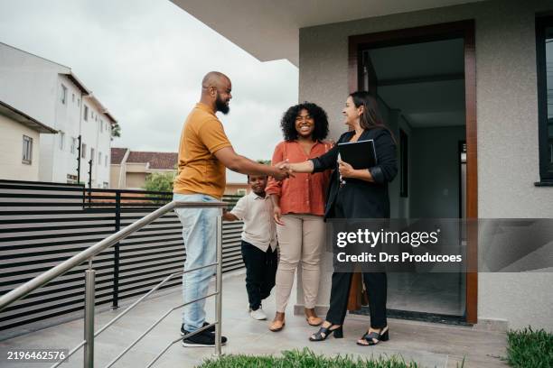 couple with a child talking to the real estate agent - real estate showing stock pictures, royalty-free photos & images
