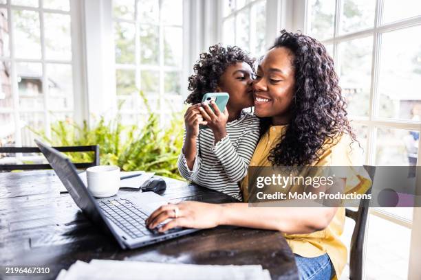 mother trying to work on laptop while her young daughter is distracting her - un jour comme les autres images en série photos et images de collection