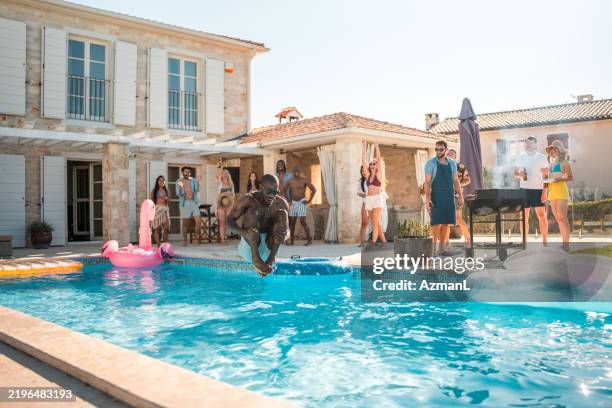 diverse friends enjoy cannonball splash at luxury villa - cannonball pool stock pictures, royalty-free photos & images