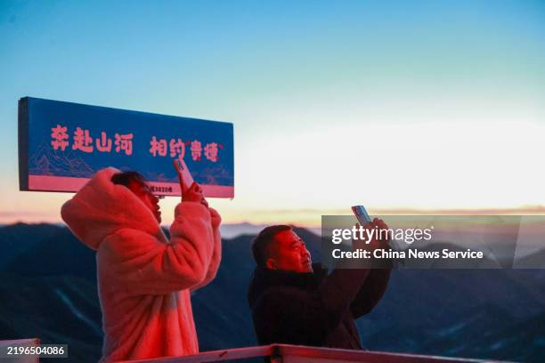 People take photos of sunrise on the Laji Mountain on the first day of Spring Festival on January 29, 2025 in Guide County, Hainan Tibetan Autonomous...