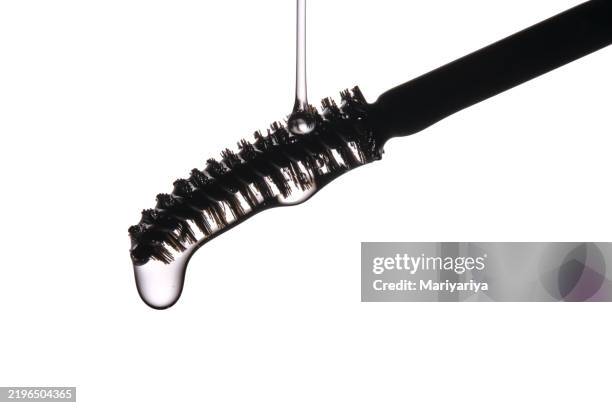 eyebrow and eyelash growth oil flows from the black brush. - thick stock pictures, royalty-free photos & images