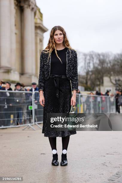 Veronika Heilbrunner wears black shirt, black unzipped Chanel tweed jacket, black high waisted sheer mesh embroidered Chanel midi skirt, shiny light...