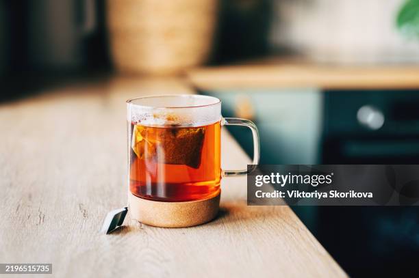 tea bag put in transparent glass teacup - theepot stockfoto's en -beelden