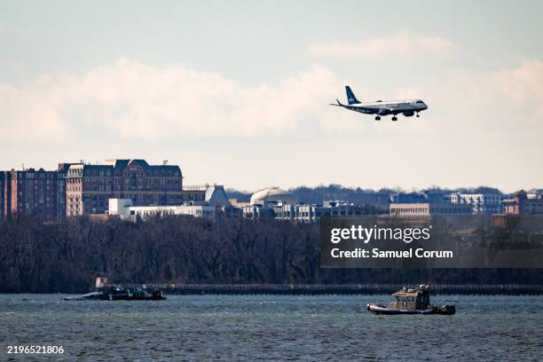 Jet Blue flight flies over law enforcement boats and the partially submerged fuselage of American Airlines Flight 5342 in the Potomac River on...