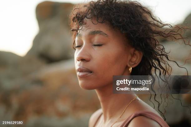 tranquil beauty portrait of a young black woman facing the sun with her eyes closed - physical description stock pictures, royalty-free photos & images