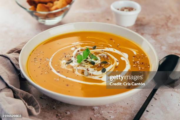 pumpkin soup with cream on brown background - pumpkin soup stock pictures, royalty-free photos & images
