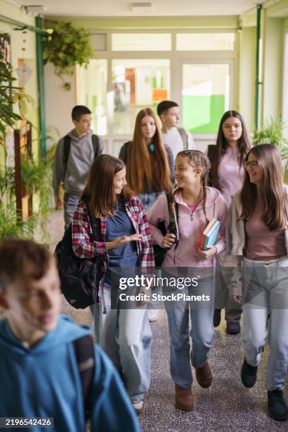 un groupe d’enfants avec des sacs à dos se promène dans le couloir de l’école - écolier-garçon photos et images de collection