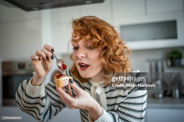 young woman making and eating bruschetta in her kitchen - sauce stock pictures, royalty-free photos & images
