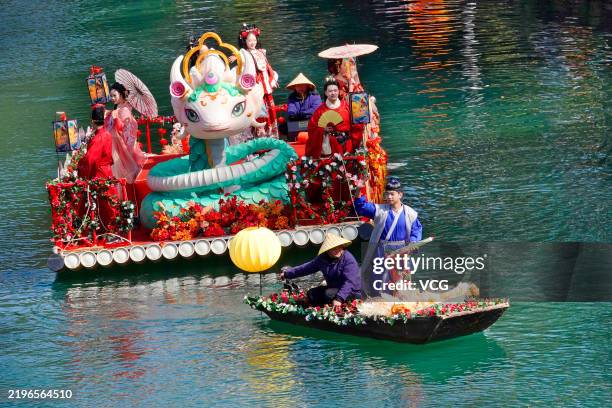 Performers dressed in traditional Hanfu costumes take part in a boat parade cruise through the Huaxi River to celebrate the Chinese New Year on...