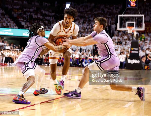 Curtis Jones of the Iowa State Cyclones protects the ball as Dug McDaniel and Brendan Hausen of the Kansas State Wildcats put defensive pressure on...
