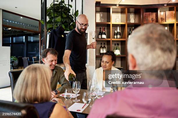 bearded sommelier pouring white for wine tasting guests - hunter valley stock pictures, royalty-free photos & images