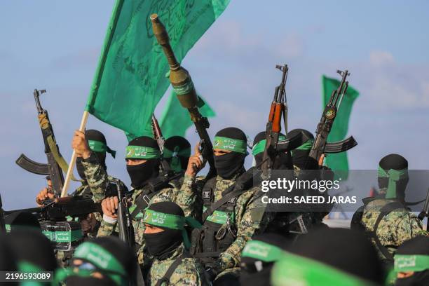 Palestinian militant group Hamas fighters secure an area before handing over an Israeli-American hostage to a Red Cross team in Gaza City on February...
