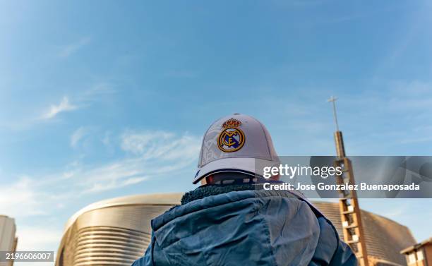 fußballfan mit real madrid kappe mit blick auf das santiago bernabéu stadion - santiago bernabéu stadion stock-fotos und bilder