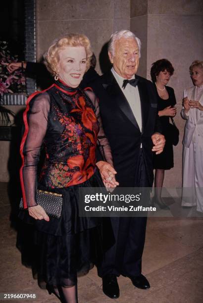 American actress, singer and dancer Nanette Fabray, wearing a red-and-black outfit, and American actor Eddie Albert, who wears a tuxedo and bow tie,...